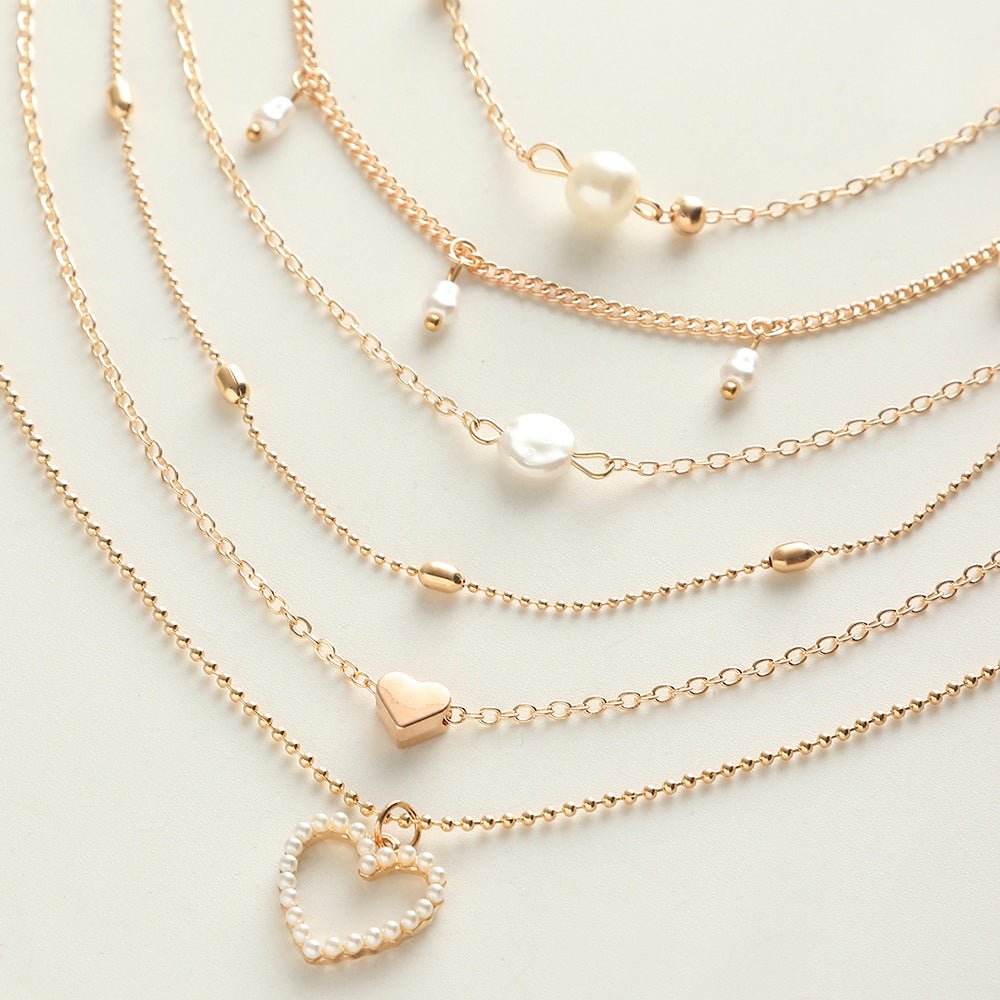 Layered Heart Necklace adorned with Pearl accents.