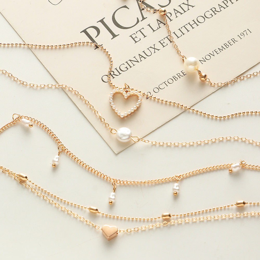 Layered Heart Necklace adorned with Pearl accents.